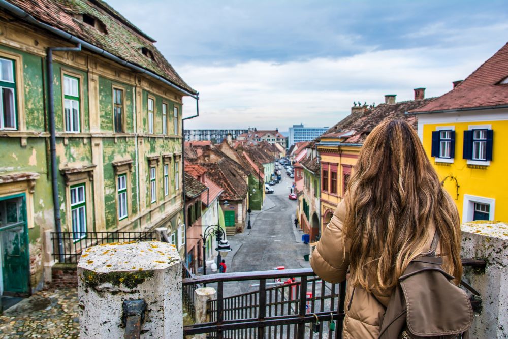 person looking out over a city street in Romania